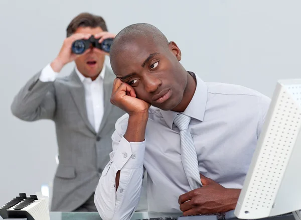 Afro-amerykański biznesmen zirytowany przez człowieka, patrząc przez binoc — Zdjęcie stockowe