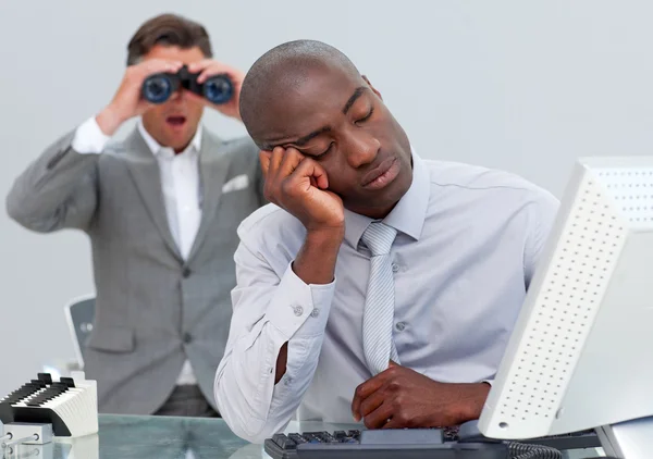 Empresário adormecido irritado por um homem olhando através de binóculos — Fotografia de Stock