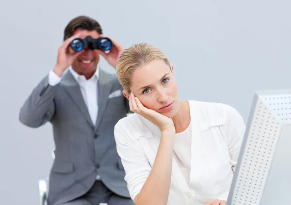 Mujer de negocios rubia molesta por un hombre mirando a través de prismáticos —  Fotos de Stock