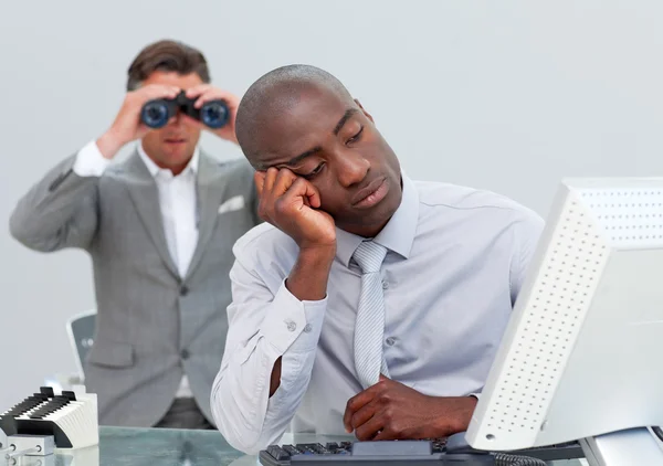 Empresário infeliz ficando entediado e seu gerente olhando através — Fotografia de Stock