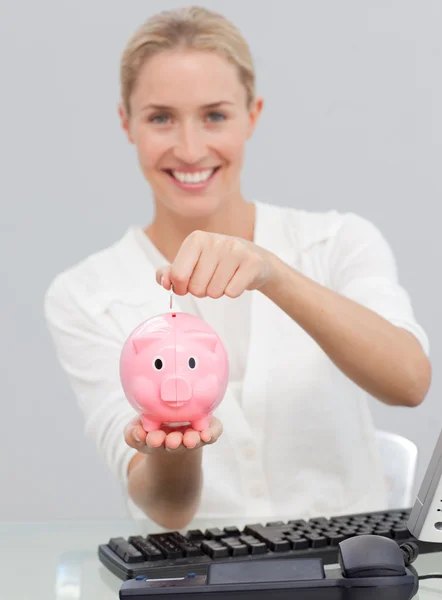 Χαμογελώντας επιχειρηματίας εξοικονόμηση χρημάτων σε ένα piggibank — Φωτογραφία Αρχείου