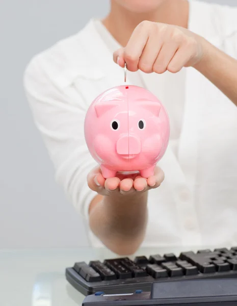 Close-up of a businesswoman saving money in a piggibank — Stock Photo, Image