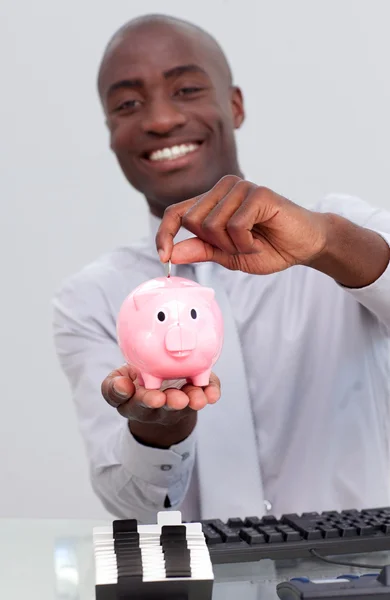 Empresário afro-americano feliz economizando dinheiro em um mealheiro — Fotografia de Stock