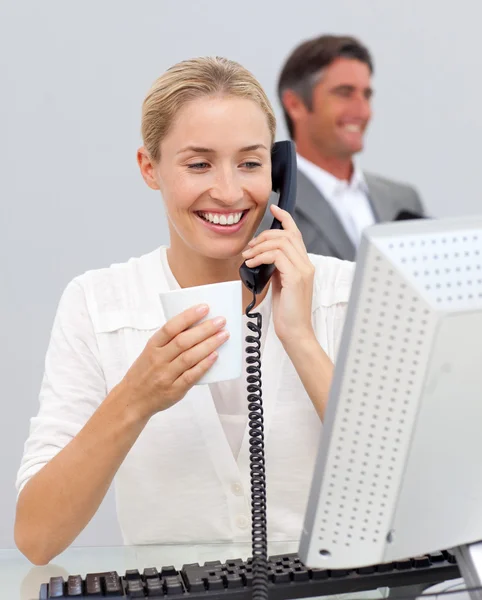 Glimlachende zakenvrouw drinken koffie en te praten over de telefoon — Stockfoto