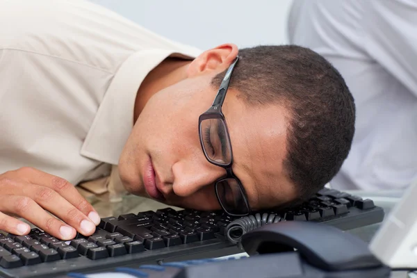 Молодой бизнесмен спит на клавиатуре — стоковое фото
