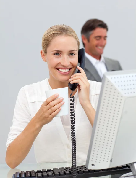 Mujer de negocios sonriente bebiendo café y hablando por teléfono — Foto de Stock