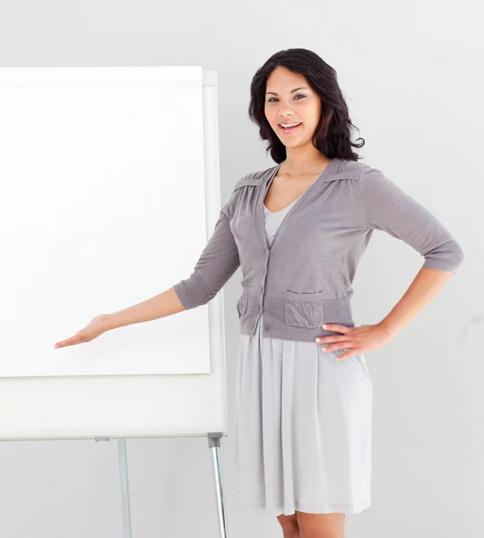 Affärskvinna ler och pekar på presentation styrelse — Stockfoto