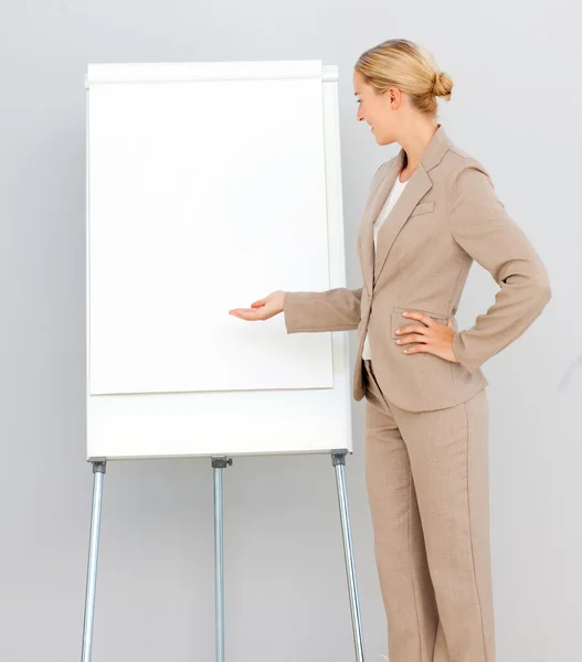 Femme d'affaires debout pointant vers un tableau blanc — Photo