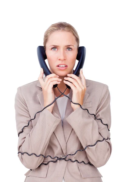 Mujer de negocios estresada atrapada en cables telefónicos — Foto de Stock