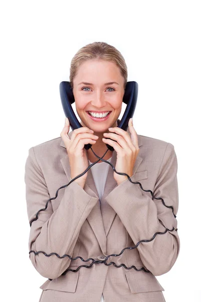 Glimlachende zakenvrouw verstrikt in telefoon draden — Stockfoto
