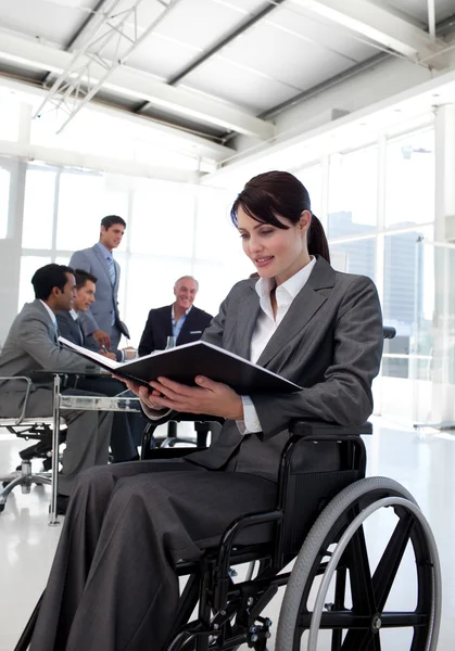 Empresaria en silla de ruedas leyendo un informe — Foto de Stock