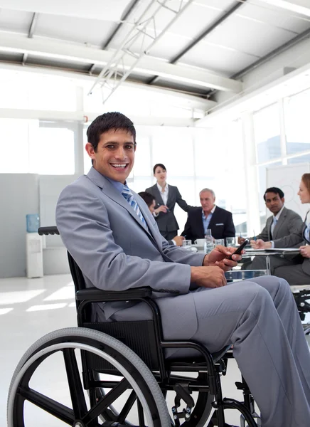 Jovem empresário em uma cadeira de rodas em uma reunião — Fotografia de Stock