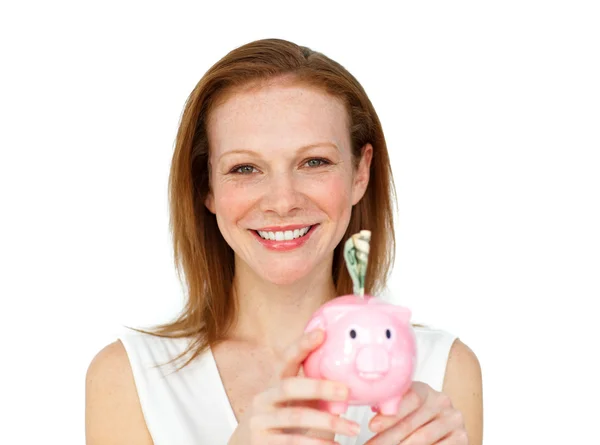 Smiling businesswoman saving money in a piggybank — Stock Photo, Image