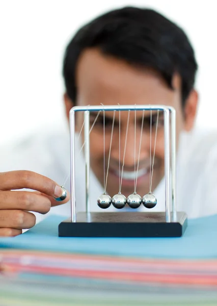 Jovem empresário se divertindo com bolas cinéticas — Fotografia de Stock