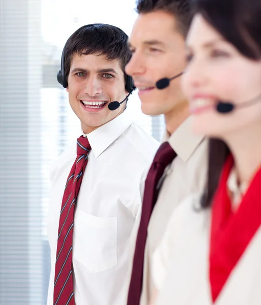 Businessman with headset on smiling at the camera — Stock Photo, Image