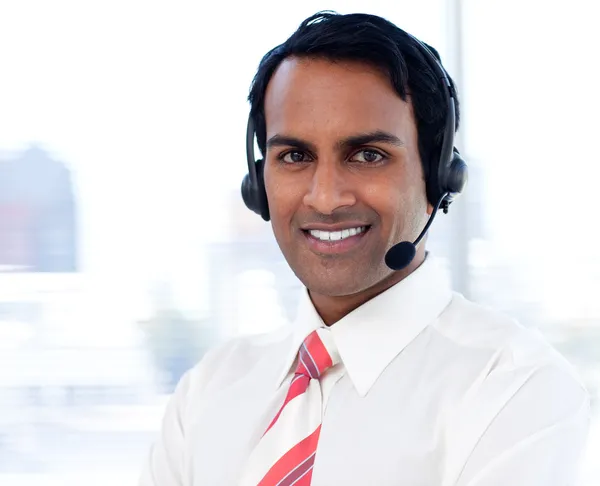 Retrato de un hombre de negocios sonriente con auriculares puestos —  Fotos de Stock