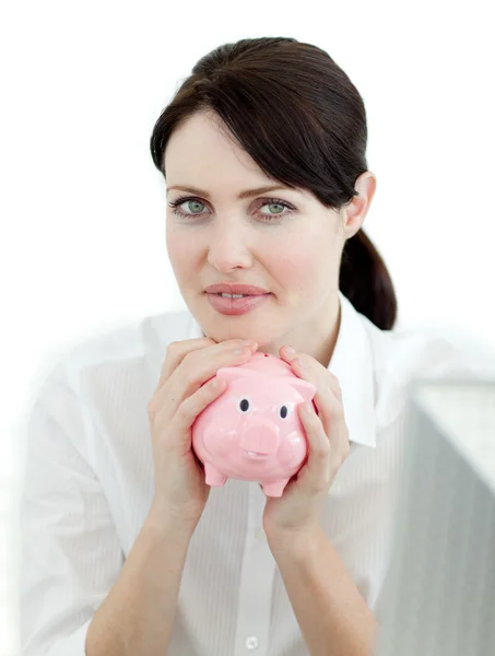 Serious businesswoman holding a piggybank — Stock Photo, Image