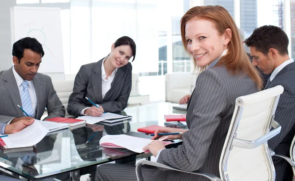 Glimlachende zakenvrouw in een vergadering met haar team — Stockfoto