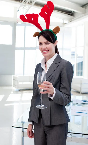 Mujer de negocios sonriente con una novedad sombrero de Navidad tostadas con —  Fotos de Stock