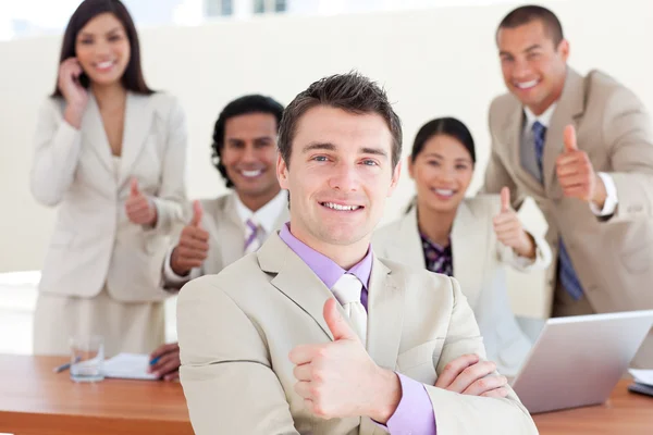 Successful manager in front of his team with thumbs up — Stock Photo, Image