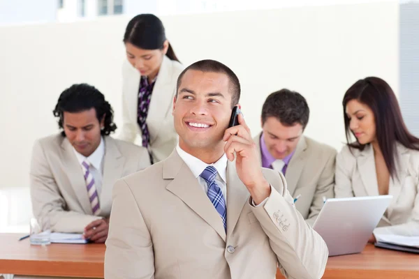 Attractive manager on phone in front of his team — Stock Photo, Image