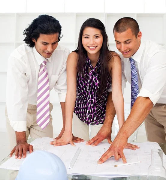 Close-up of a diverse group of engineers reviewing blueprints — Stock Photo, Image