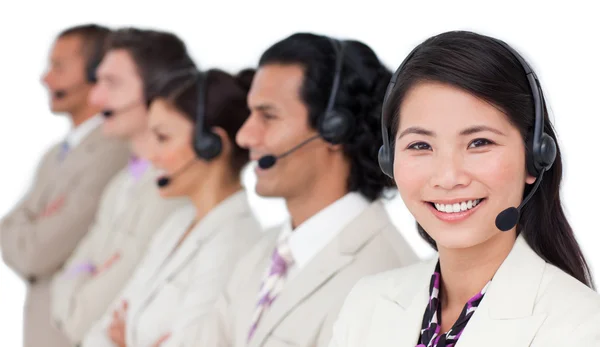 Equipe de negócios confiante com fone de ouvido em pé em uma fileira — Fotografia de Stock