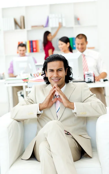 Cheerful manager sitting with his team in the background — Stock Photo, Image