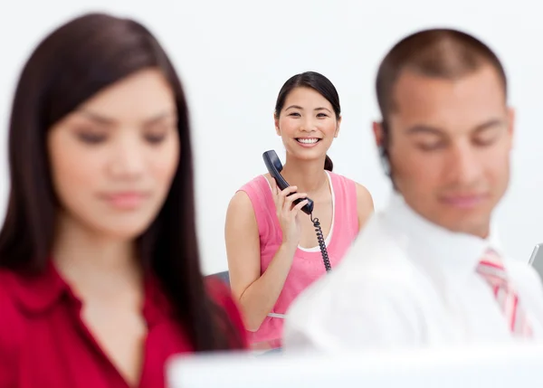 Glad affärskvinna på telefon med sina kollegor i foregrou — Stockfoto