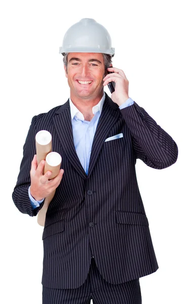 Smiling businessman on phone and holding blueprints — Stock Photo, Image