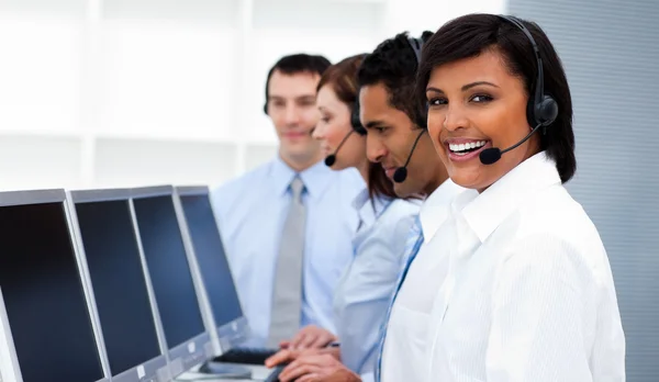 Felices compañeros de trabajo con auriculares en el centro de llamadas —  Fotos de Stock