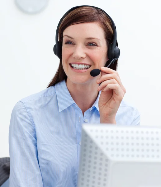 Säker affärskvinna med hörlurarna på i ett callcenter — Stockfoto