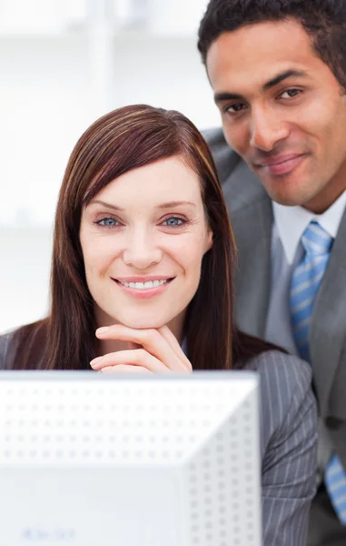 Dos colegas sonrientes trabajando en una computadora — Foto de Stock