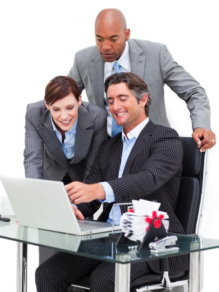 Радісний бізнесмен показує щось на ноутбуці своїй команді — стокове фото
