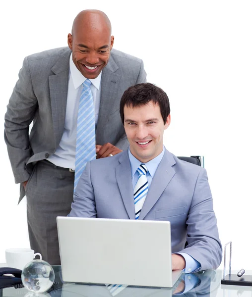 Ethnic manager assisting his colleague at a computer — Stock Photo, Image
