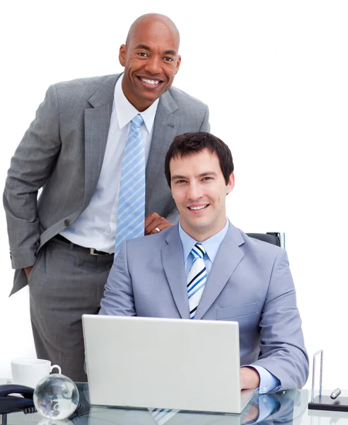 Lachende manager helpen zijn collega op een computer — Stockfoto