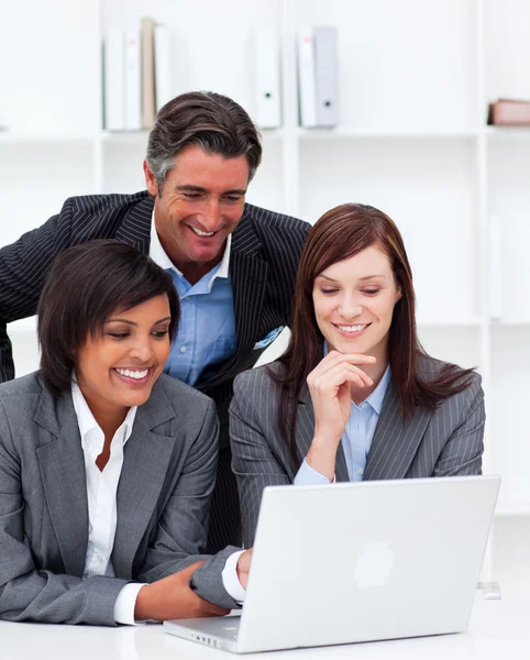 Lachende vrouwelijke ondernemers en hun collega werken op een laptop — Stockfoto