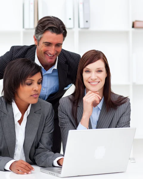 Mulheres de negócios positivas e seu colega trabalhando em um laptop — Fotografia de Stock