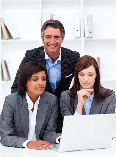 Mulheres de negócios sérias e seu colega trabalhando em um laptop — Fotografia de Stock