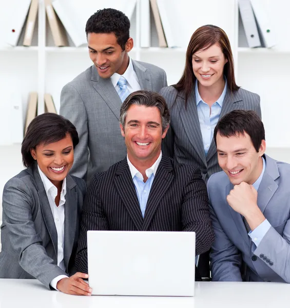 Equipe de negócios alegre olhando para um laptop — Fotografia de Stock