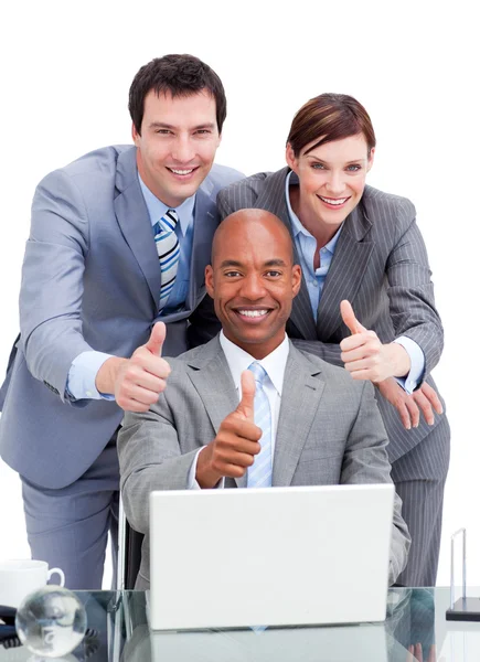 Diversos colegas de negócios com os polegares em um laptop — Fotografia de Stock