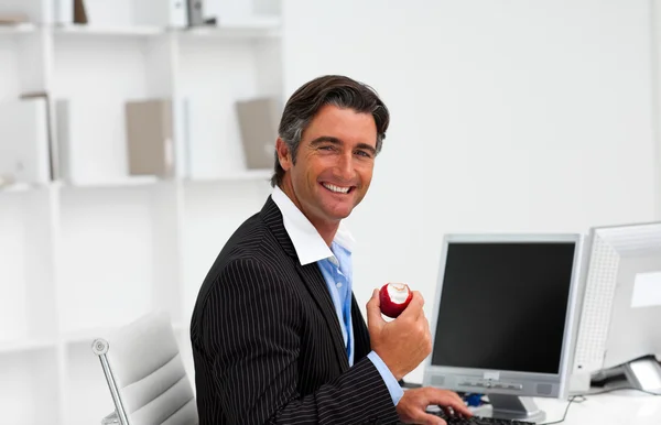 Επιχειρηματίας, τρώγοντας ένα φρούτο στην εργασία — Φωτογραφία Αρχείου