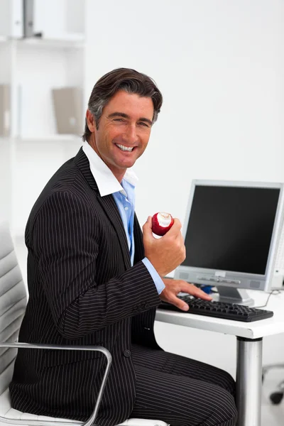 Kırmızı elma tutan gülümseyen iş adamı — Stok fotoğraf