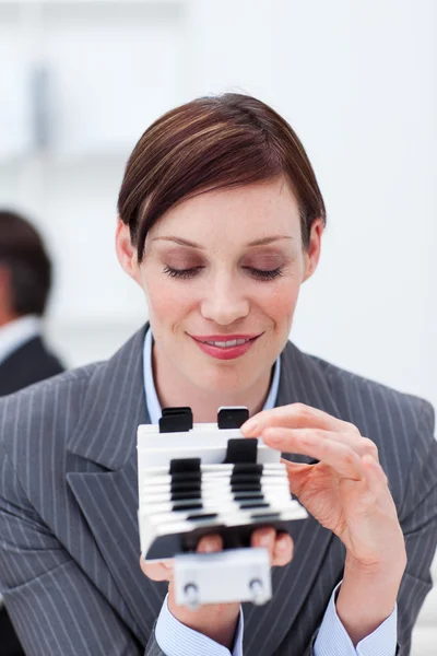 Empresária atraente consultando seu titular do cartão de visita — Fotografia de Stock