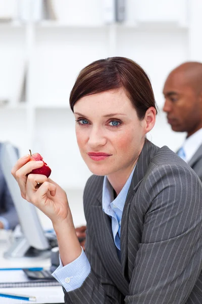 Молодая бизнесвумен ест яблоко — стоковое фото