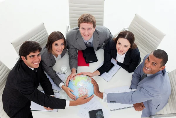 Ler business laget innehar en terrestrial globe — Stockfoto