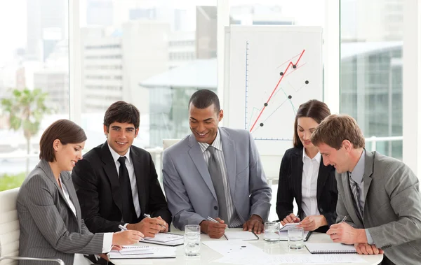 Multi-etnische zakelijke team zitten rond een conferentietafel — Stockfoto