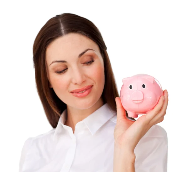 Serious attractive businesswoman looking at a piggybank — Stock Photo, Image