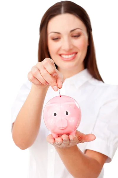 Attractive businesswoman saving money in a piggybank — Stock Photo, Image