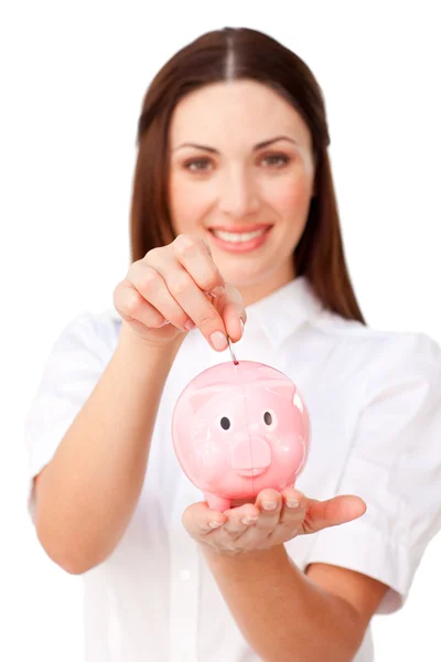 Young brunette businesswoman saving money in a piggybank — Stock Photo, Image
